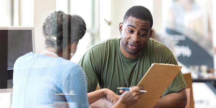 veteran student reviewing application for enrollment with woman